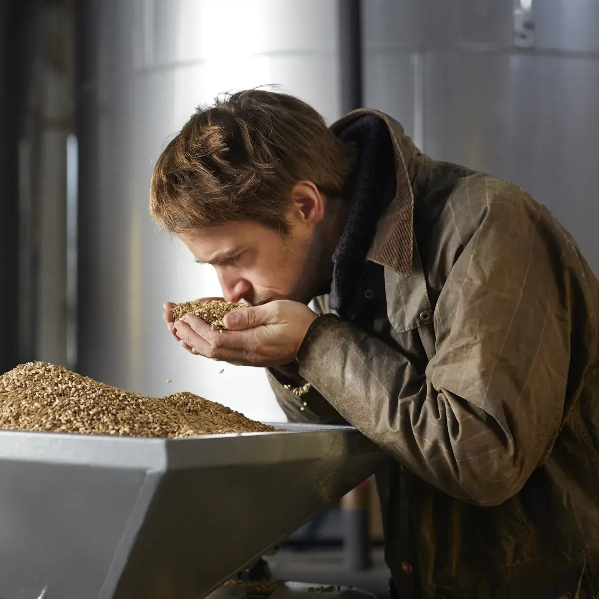 Étienne sent une poignée de malt à la distillerie