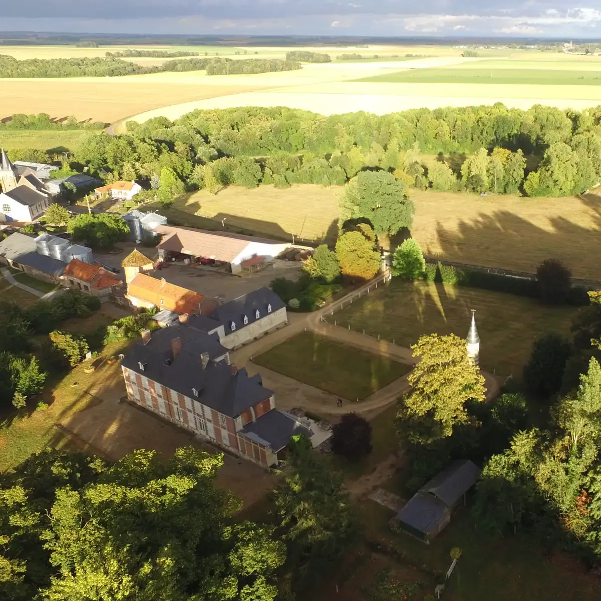 Vue aérienne du domaine d’Hautefeuille : le château, son parc, les bâtiments de la ferme et la plaine du Santerre