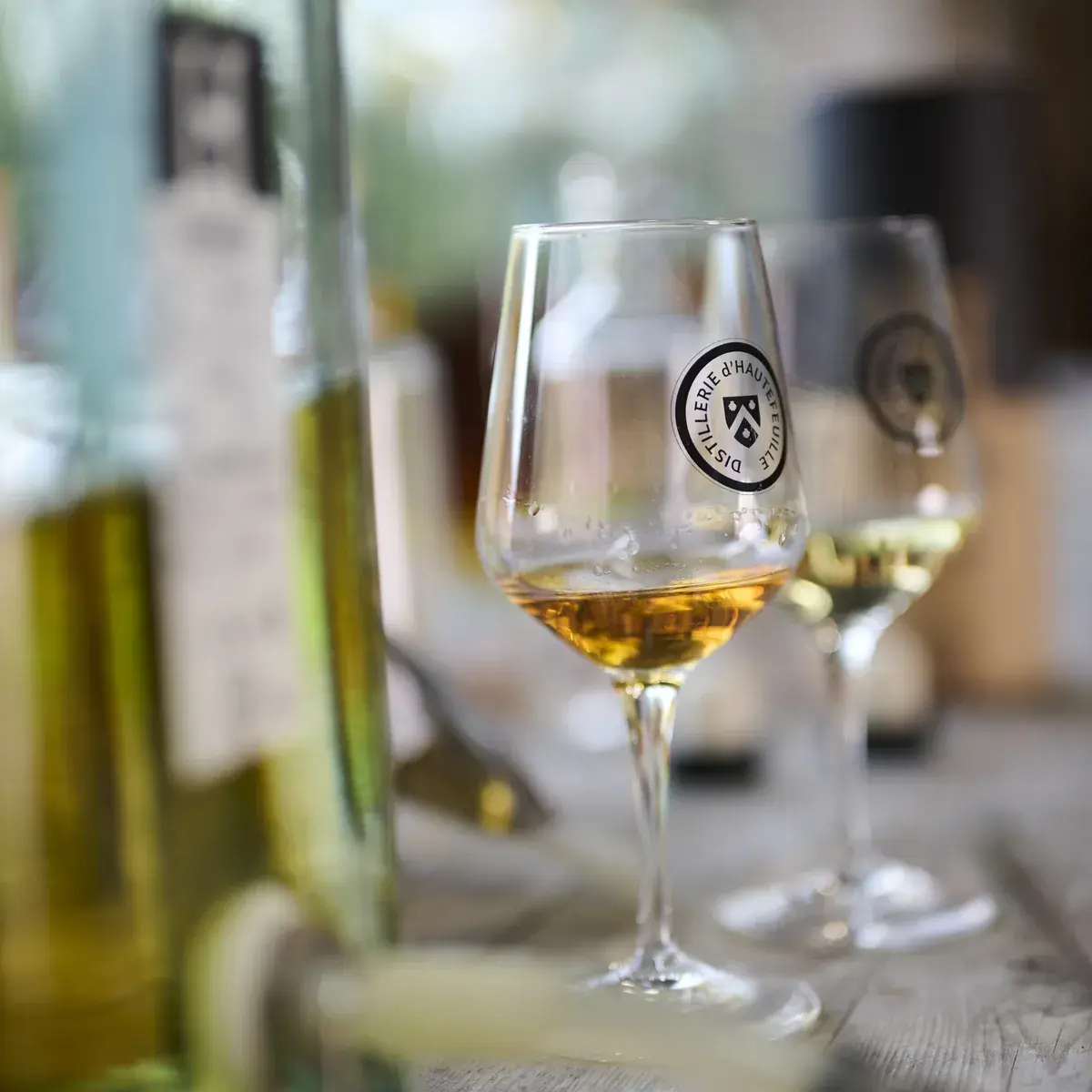 Deux verres de dégustation marqués du sceau de la distillerie, devant les fioles de l’atelier d’assemblage