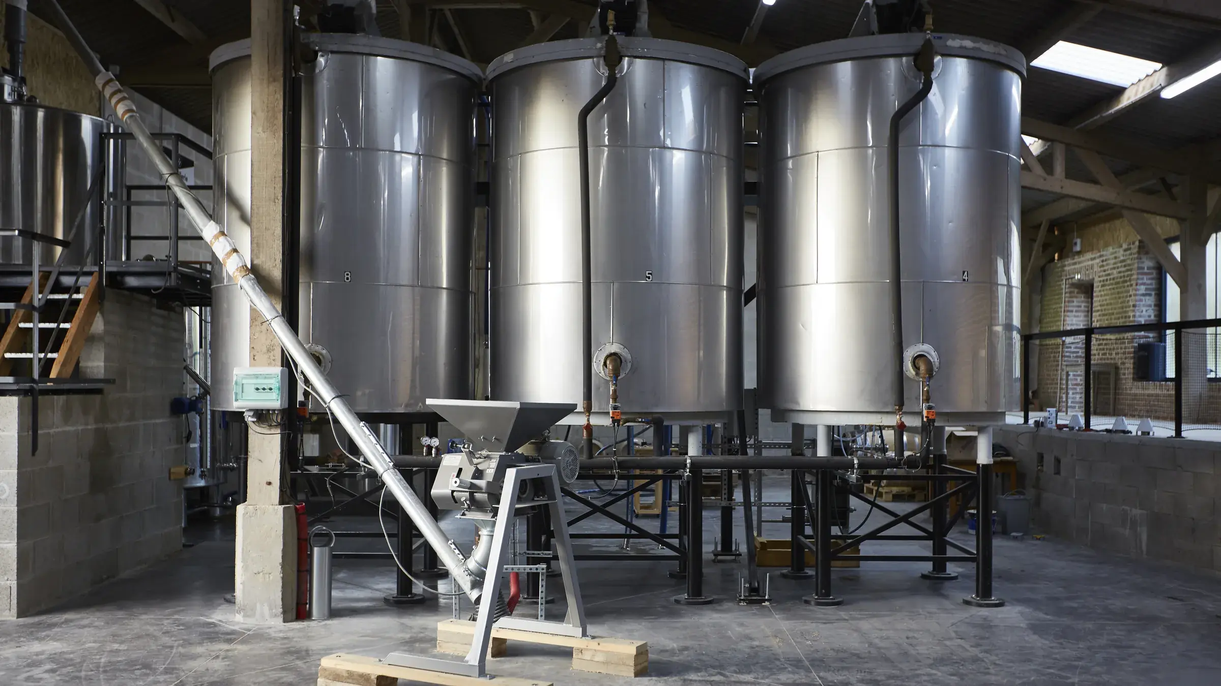 Salle de brassage et ses cuves en inox sous la charpente