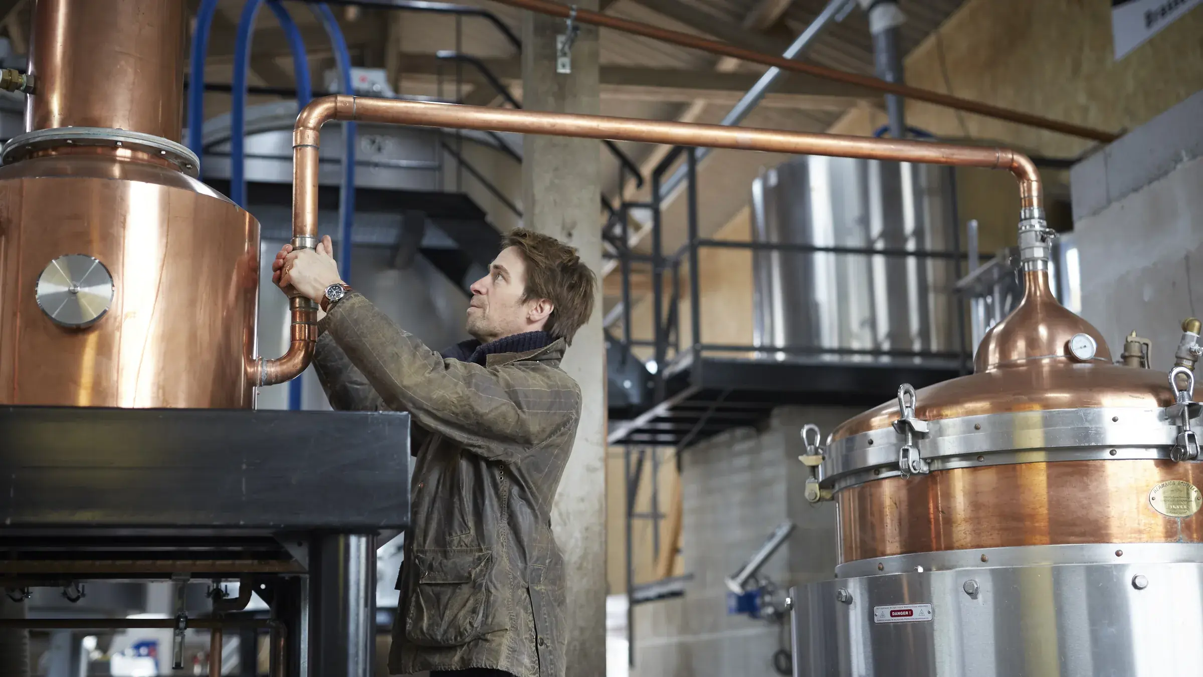 Étienne d’Hautefeuille entre les deux alambics Stupfler de la distillerie