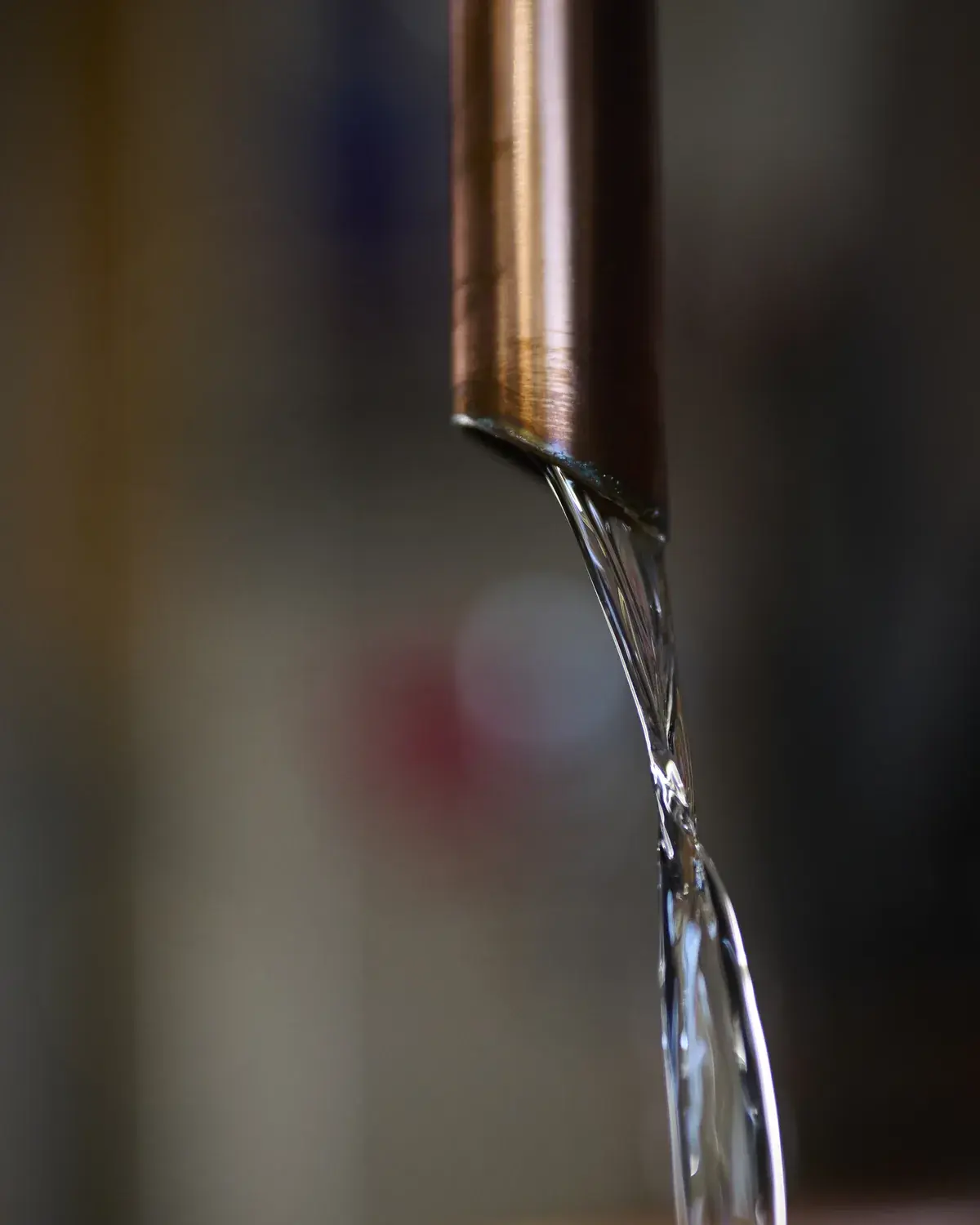 Filet de distillat clair qui coule du bec en cuivre de l’alambic